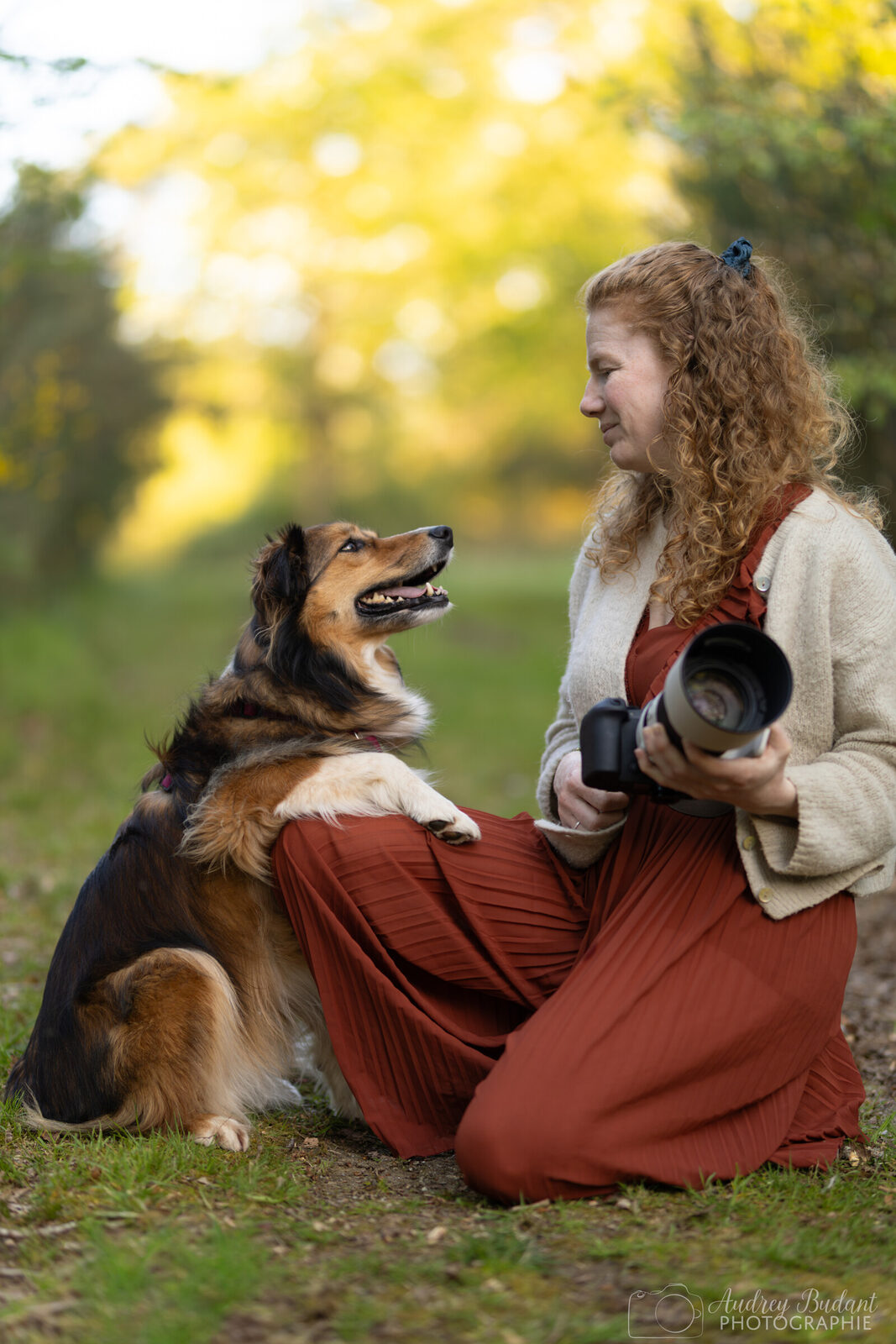 Jeune femme avec un appareil photo et sa chienne qui la regarde